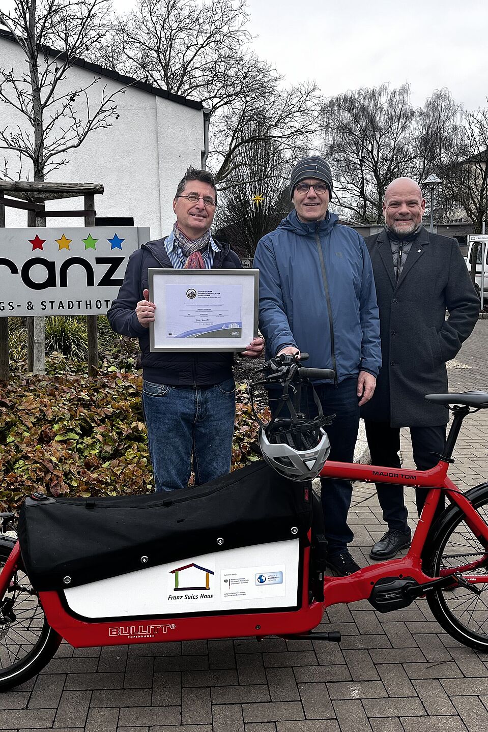 "Fahrradfreundlicher Arbeitgeber" Zertifikatsübergabe (Gold) Trägerverein Franz Sales Haus in Essen am 4. Februar 2025 Das inklusive Hotel Franz in Essen (zertifizierter Bett+Bike-Betrieb) gehört zum re-zertifizierten "Fahrradfreundlichen Arbeitgeber", dem Trägerverein des Franz Sales Haus. Von links: Andreas K. Bittner (ADFC-Projekt "Fahrradfreundlicher Arbeitgeber"), Ewald Brüggemann (Radverkehrskoordinator und Sportlicher Leiter DJK Franz Sales Haus e. V.) und der neue Geschäftsführer des Trägervereins Holger Gierth.