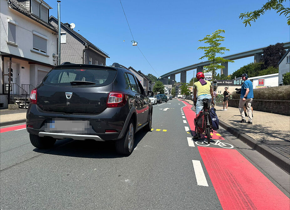 Auto überholt Radfahrer Eine Person im Auto überholt einen Radfahrer in Siegen-Eiserfeld auf der Eiserfelder Straße.