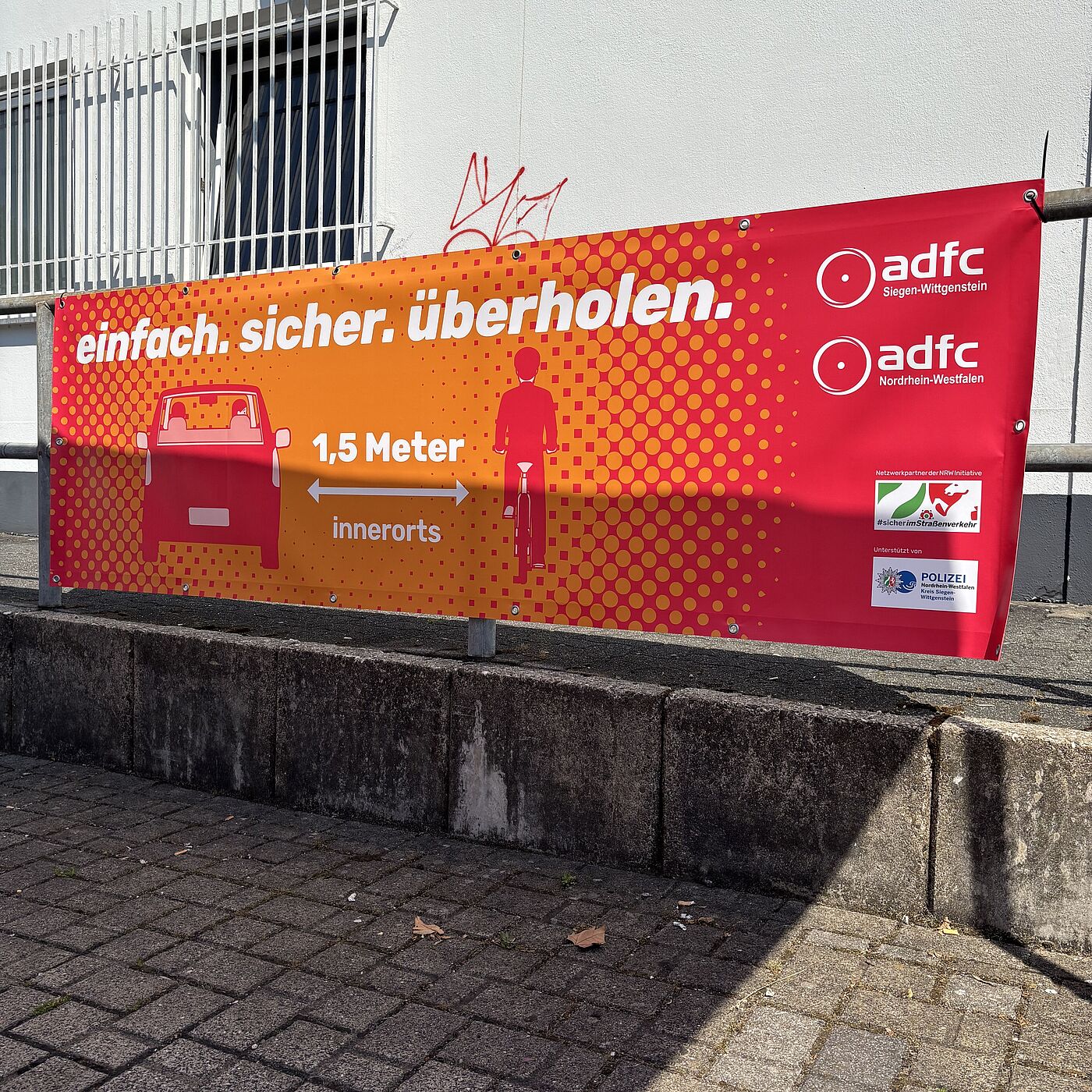 Brückenbanner einfach. sicher. überholen. Ein Banner weist auf den gesetzlich vorgeschriebenen Überholabstand von 1,5 Metern innerorts hin.