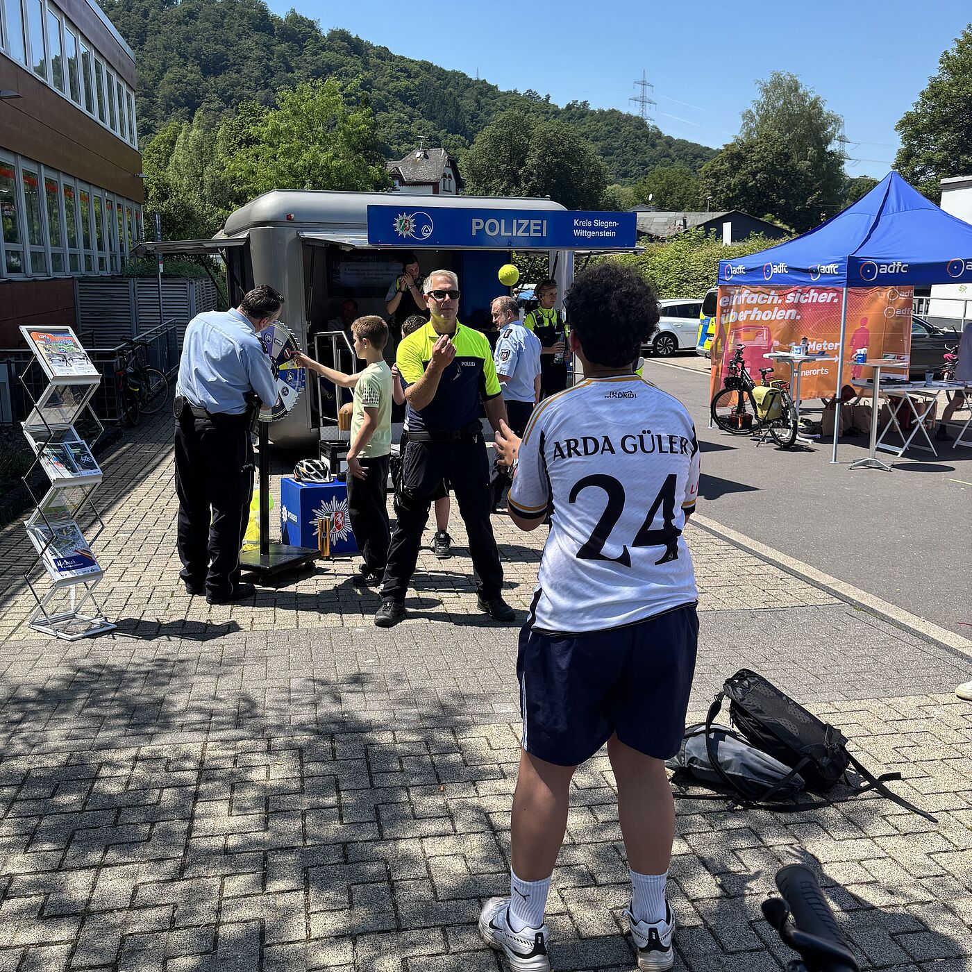 Spiel Simulation Betrunkenheit Ein Polizist und ein Schüler testen die Reaktionsfähigkeit bei einem Ballspiel mit einer Brille, die Betrunkenheit simuliert.